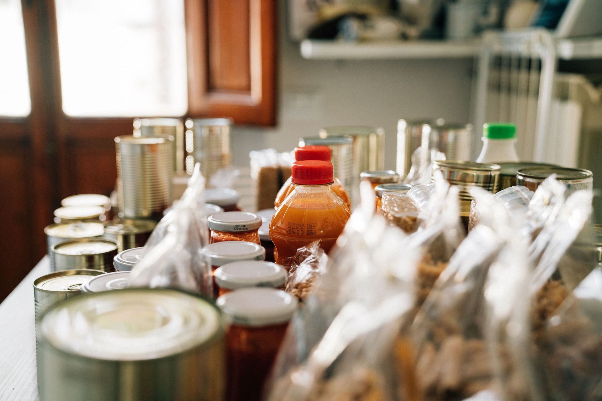 Many cans and bottles on a table at the food bank
